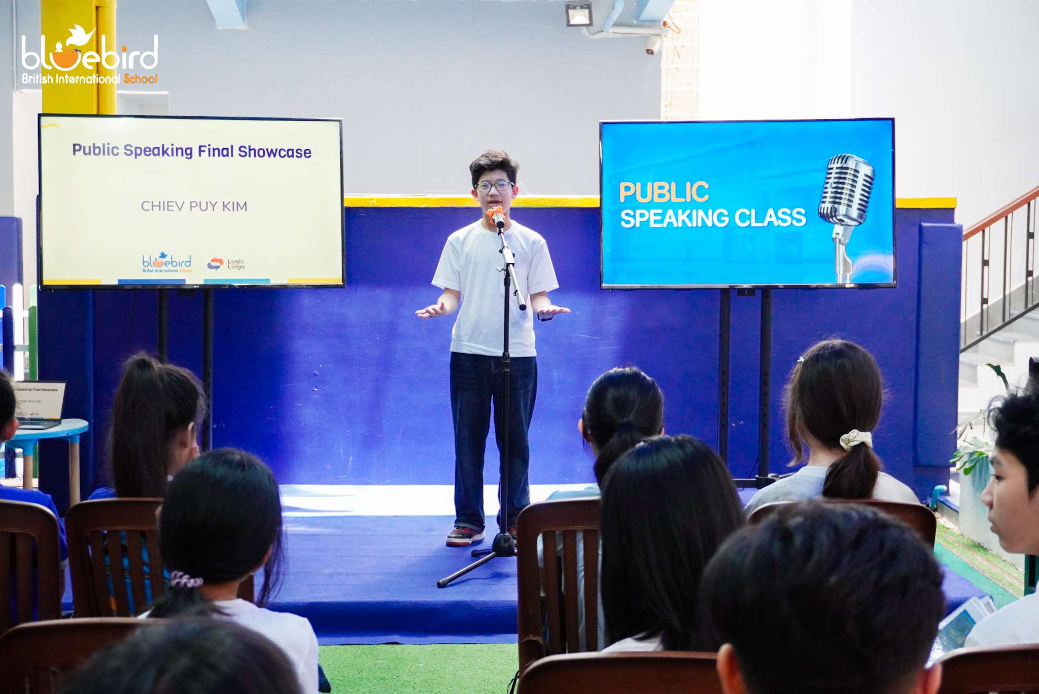 Young student confidently speaking on stage at Bluebird British International School’s public speaking showcase