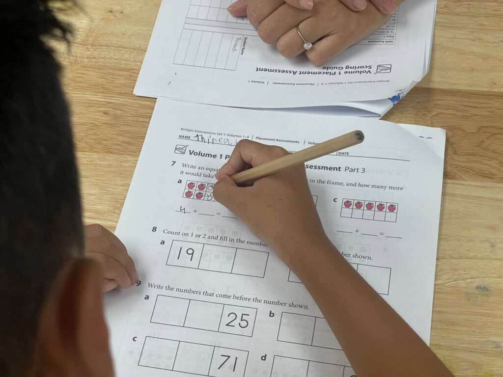 Alt Text (SEO-Optimized):Therapist at OrbRom Center guiding two young children through a hands-on learning activity in a supportive special education environment in Phnom Penh.