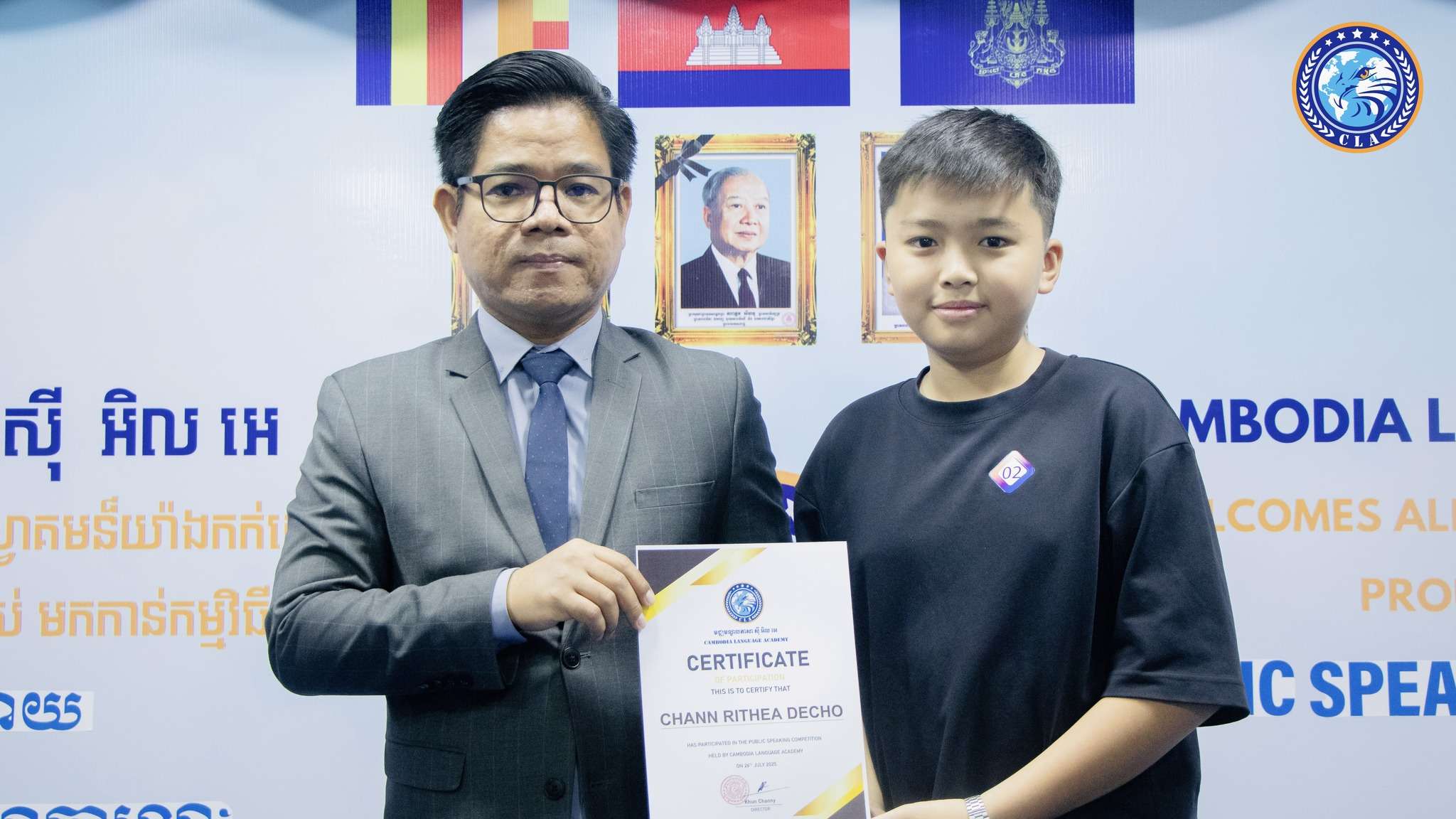Student receiving a certificate during the Cambodia Language Academy Public Speaking Award Ceremony in Phnom Penh, July 2025