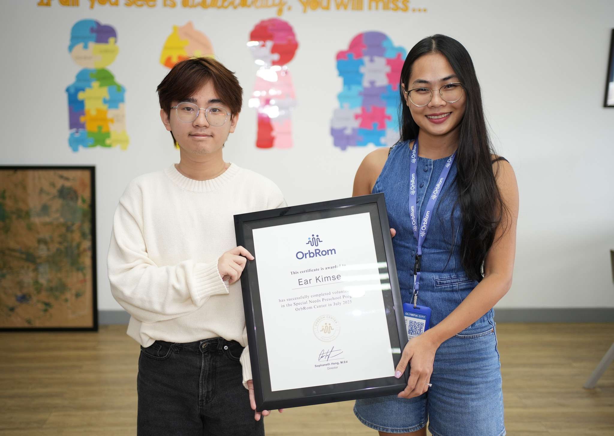 Student Ear Kimse receiving volunteer certificate at OrbRom Center Phnom Penh