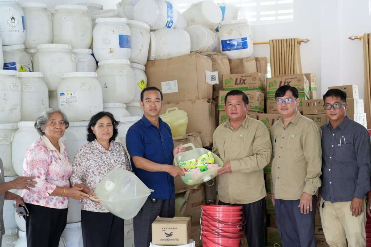 UNICEF Cambodia and Ministry of Rural Development staff unloading hygiene kits and water supplies from a white truck to support displaced families in Pursat province