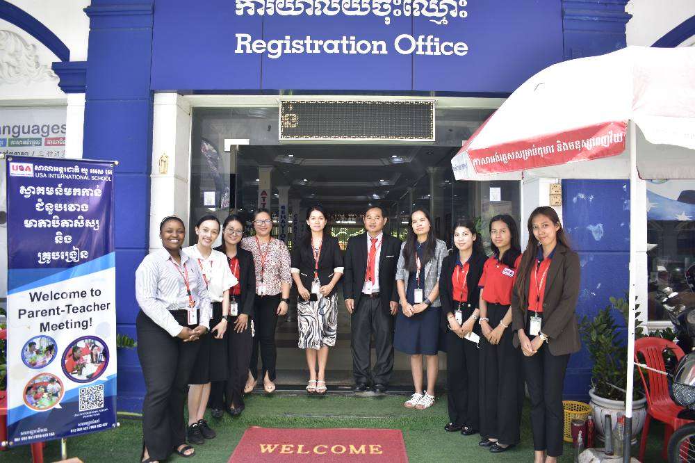 Parents and teachers from USA International School Phnom Penh discussing student progress during a parent-teacher meeting, highlighting collaborative engagement.