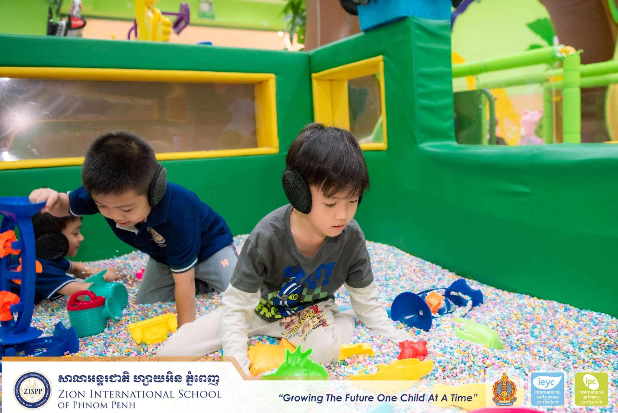 Young children engaged in interactive and physical play activities at Zion International School of Phnom Penh indoor learning facilities.
