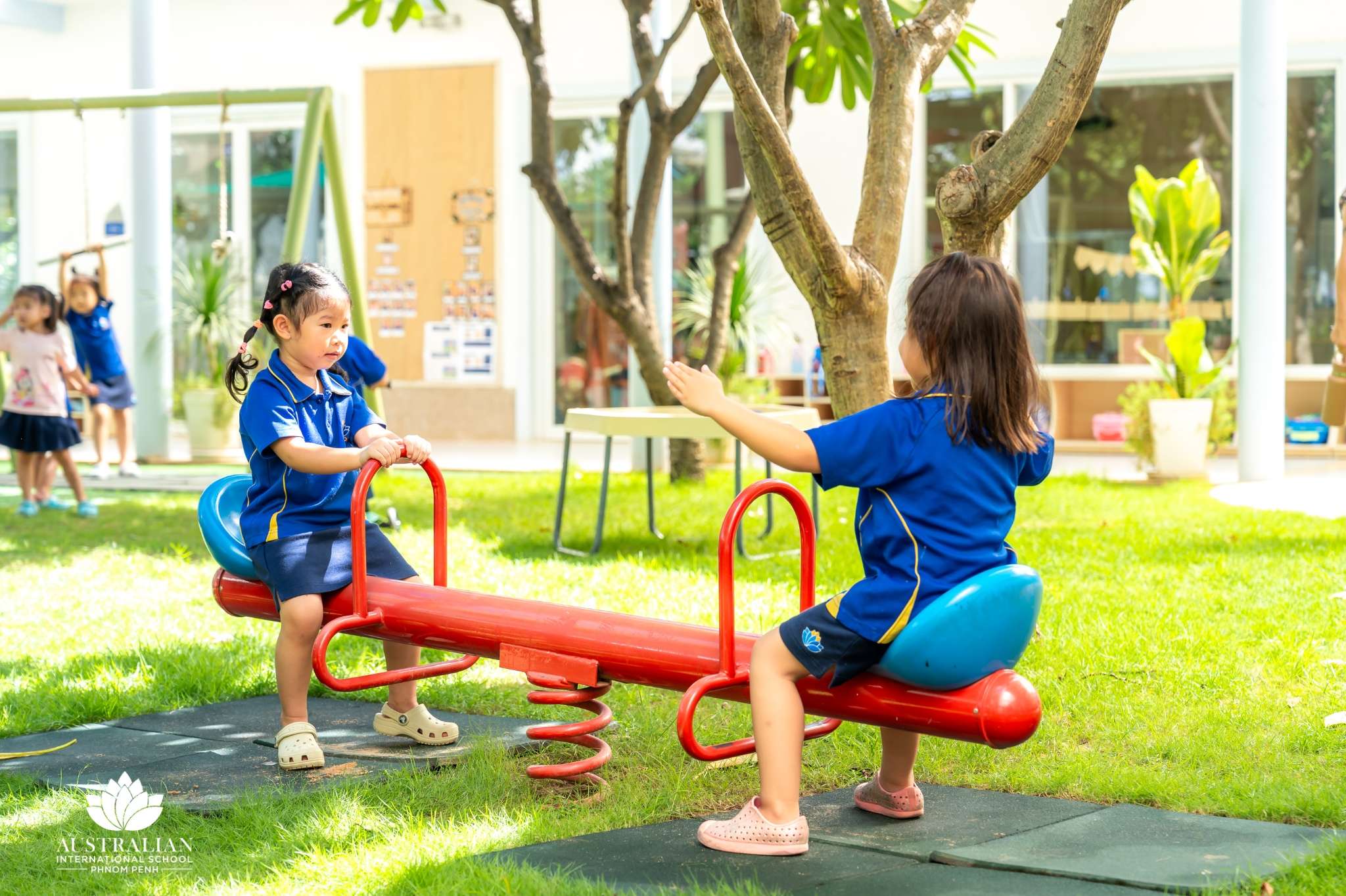 Children at AISPP engaging in play-based learning activities, including outdoor play, teamwork, and creative exploration as part of the IB programme.