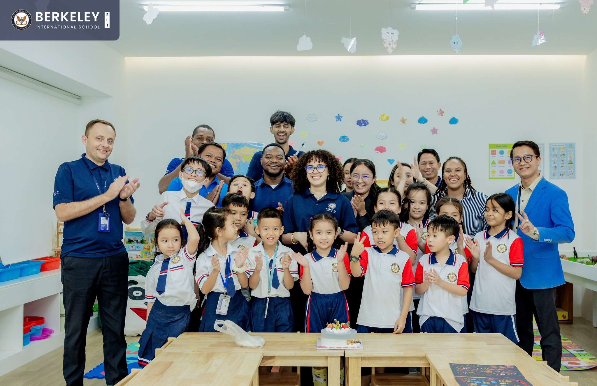 Group photo of students and staff at Berkeley International School celebrating the farewell of Teacher Nicole with smiles and a cake.