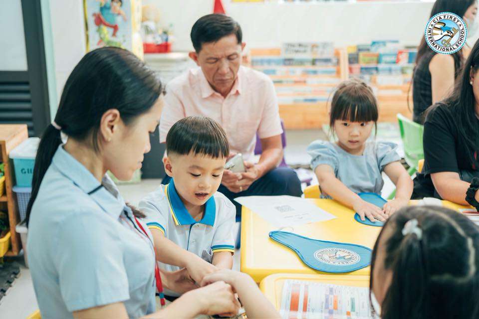 Teacher interacting with parents and children during CIA FIRST International School back-to-school session.