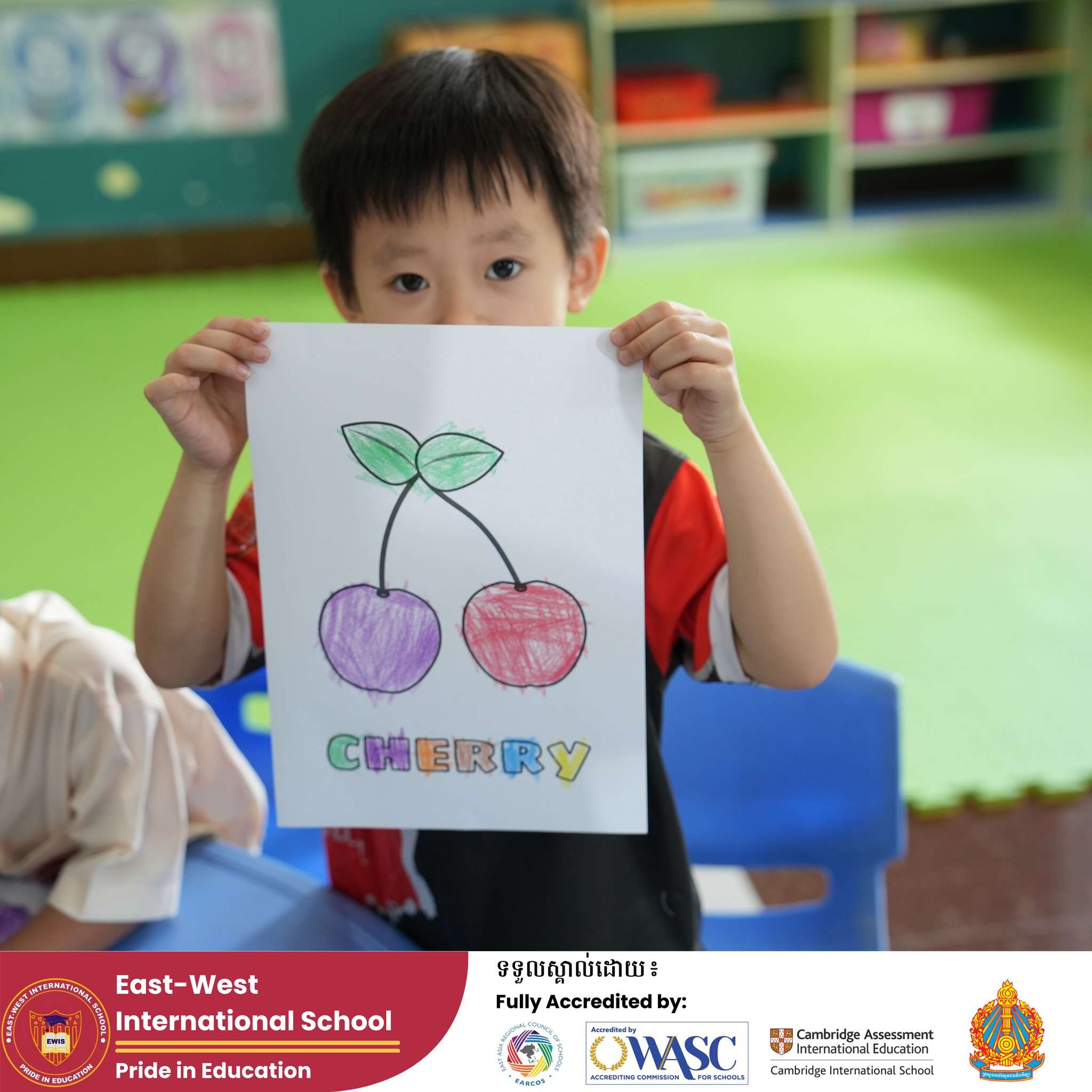 Children at East-West International School Cambodia participating in Pre-K activities—one holding a drawing of cherries, another engaging in fine motor learning.