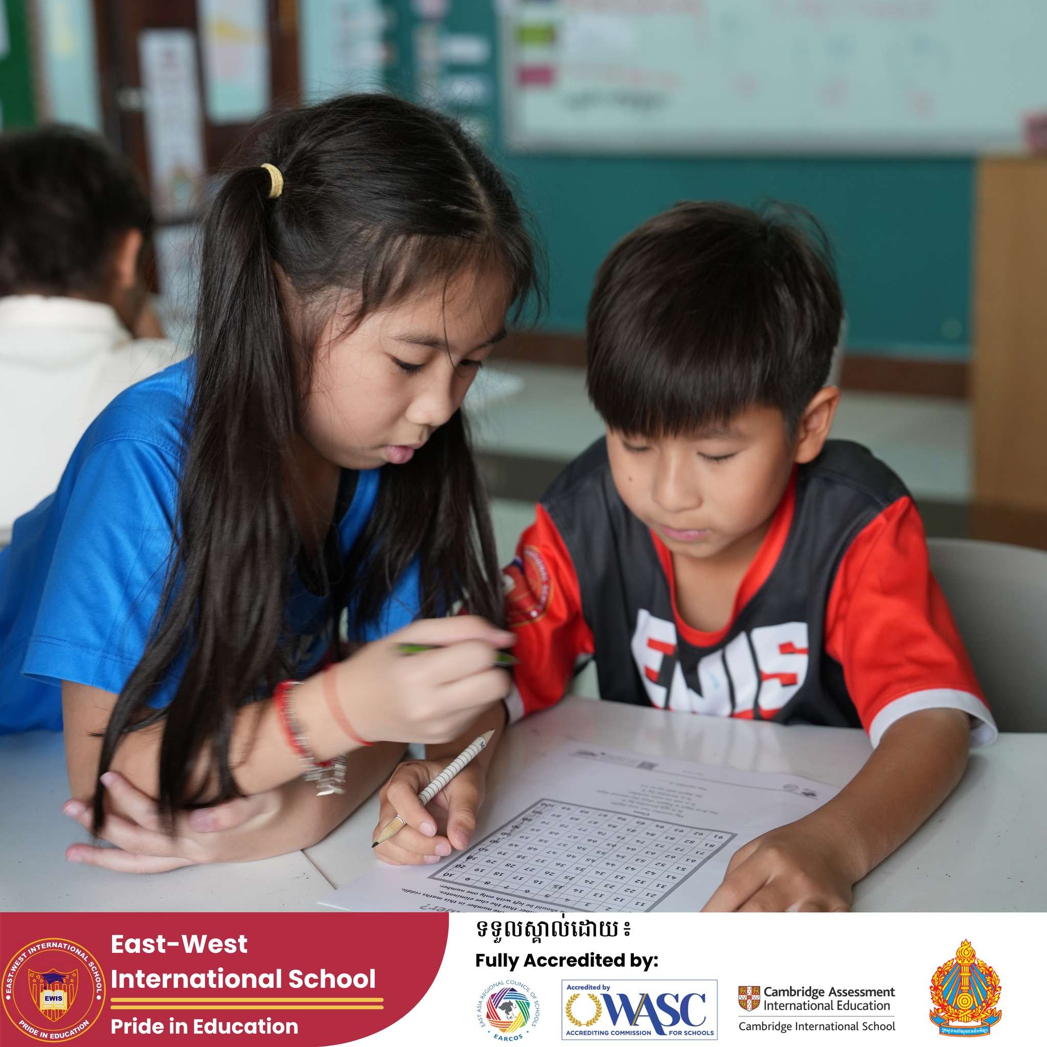 Students at East-West International School Cambodia working together on puzzles during after-school activities.