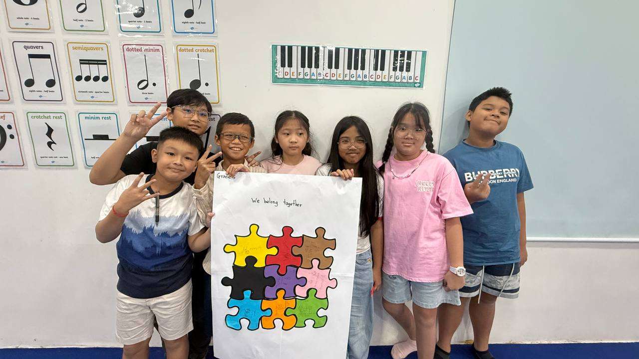 Students at Eco International School holding a poster with a puzzle design promoting unity during the anti-bullying workshop.