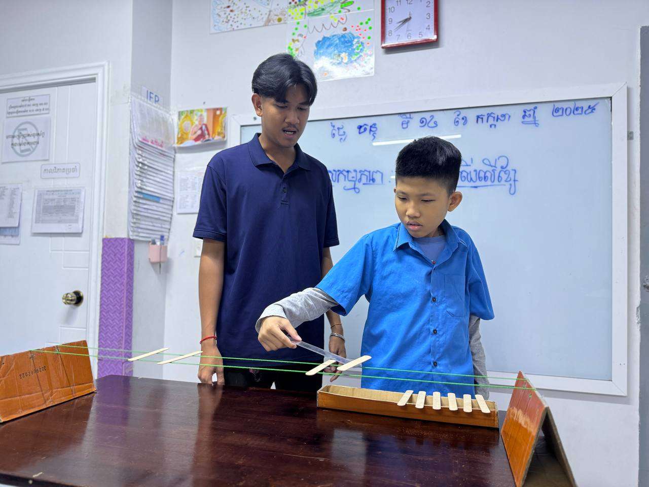 A teacher guiding students with autism at Growing Special Education School in playing a xylophone during a music therapy session