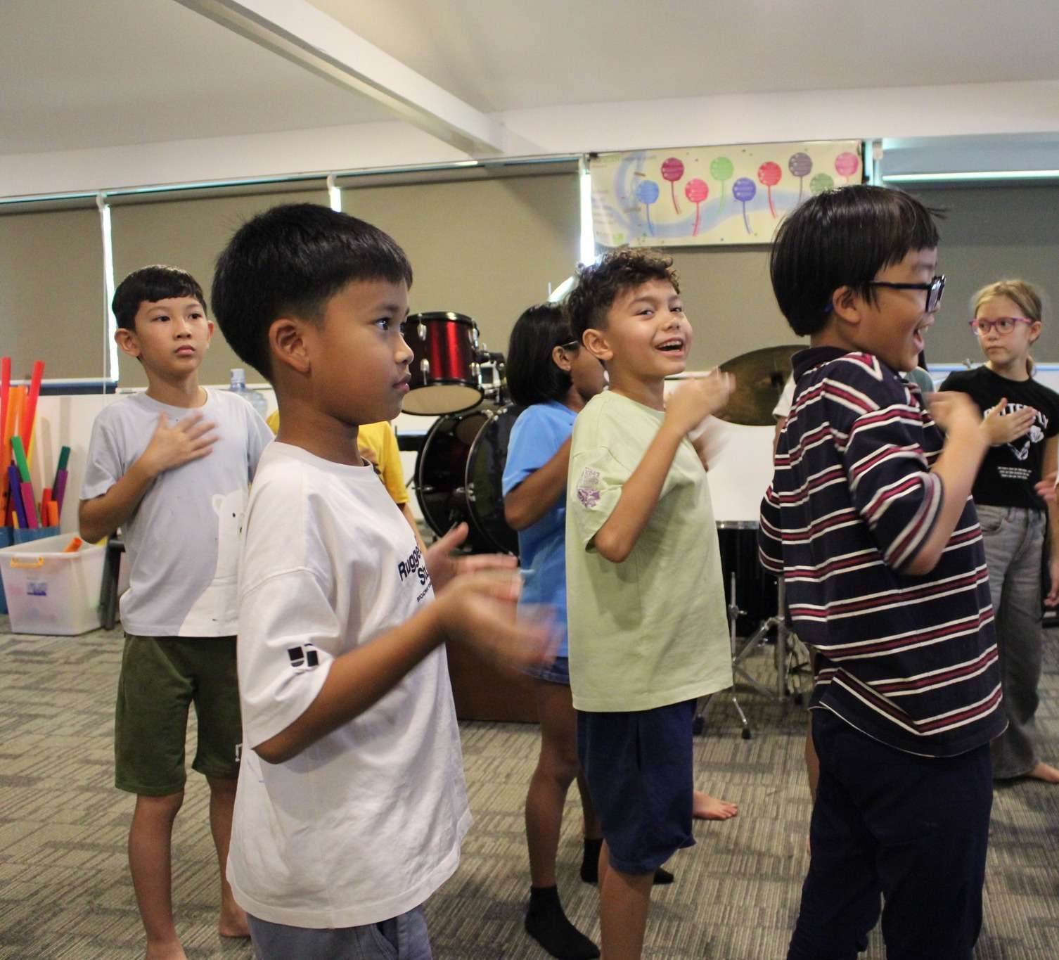 Students at iCAN British International School Phnom Penh participating in a Year 5 body percussion music class, clapping and coordinating rhythm together.