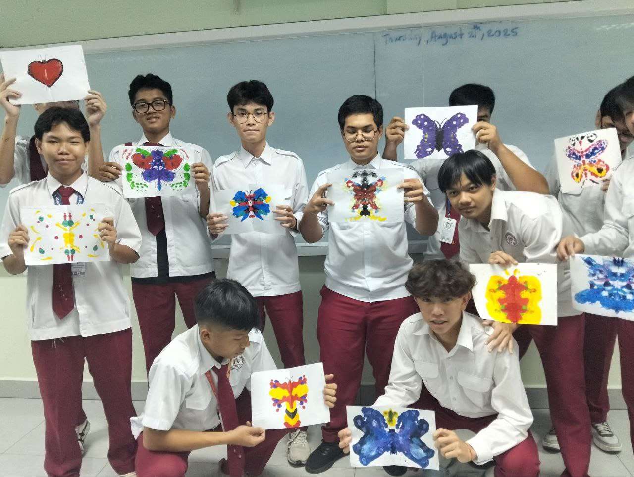 Student holding butterfly color mixing art piece at Cambodia Adventist International School