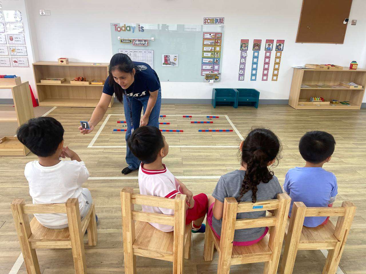Teacher guiding preschool children in classroom activities at OrbRom Preschool Phnom Penh