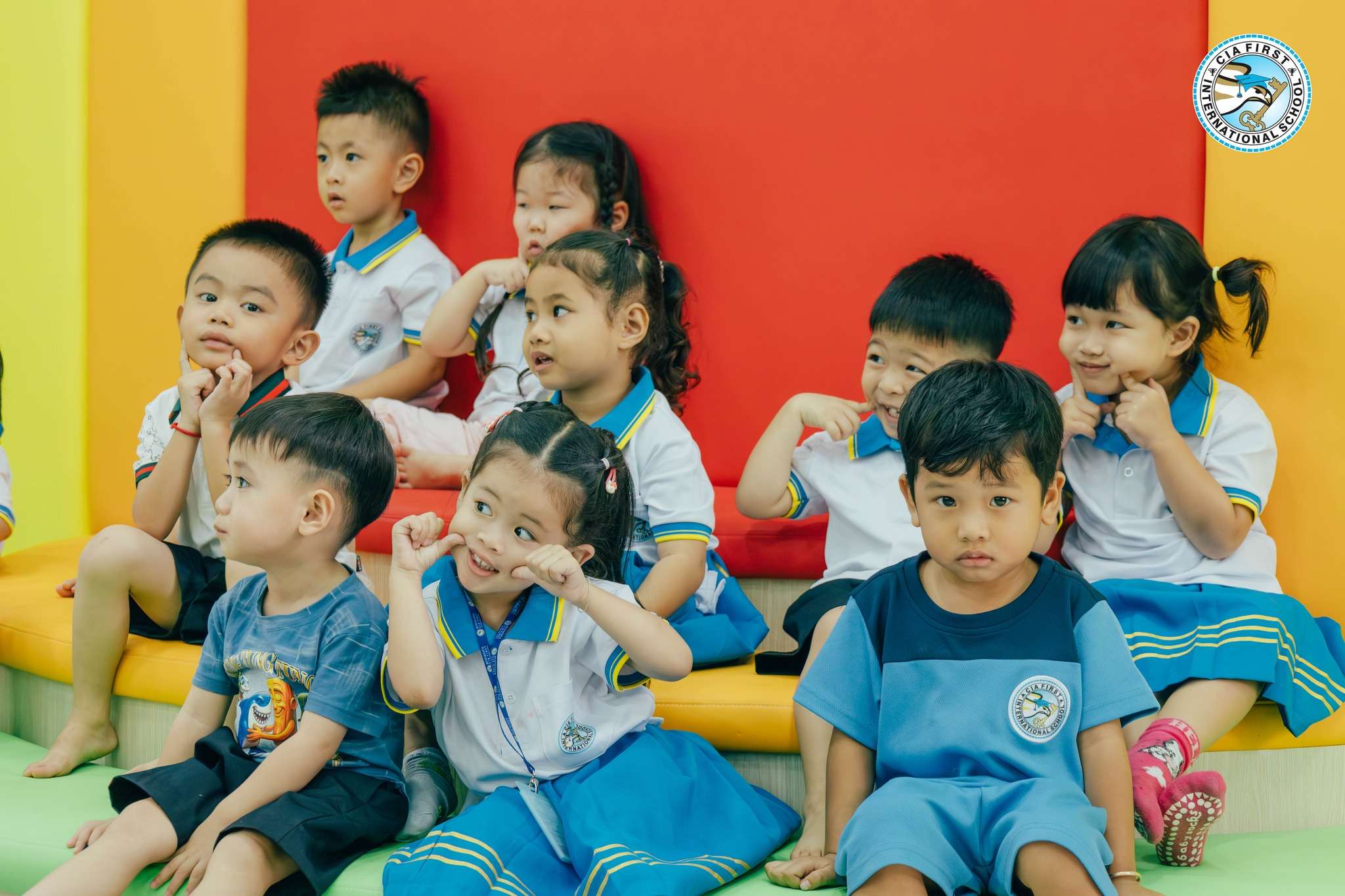 Children at CIA FIRST International School exploring the new Fablewood kindergarten library with their teacher, surrounded by colorful books and learning spaces.