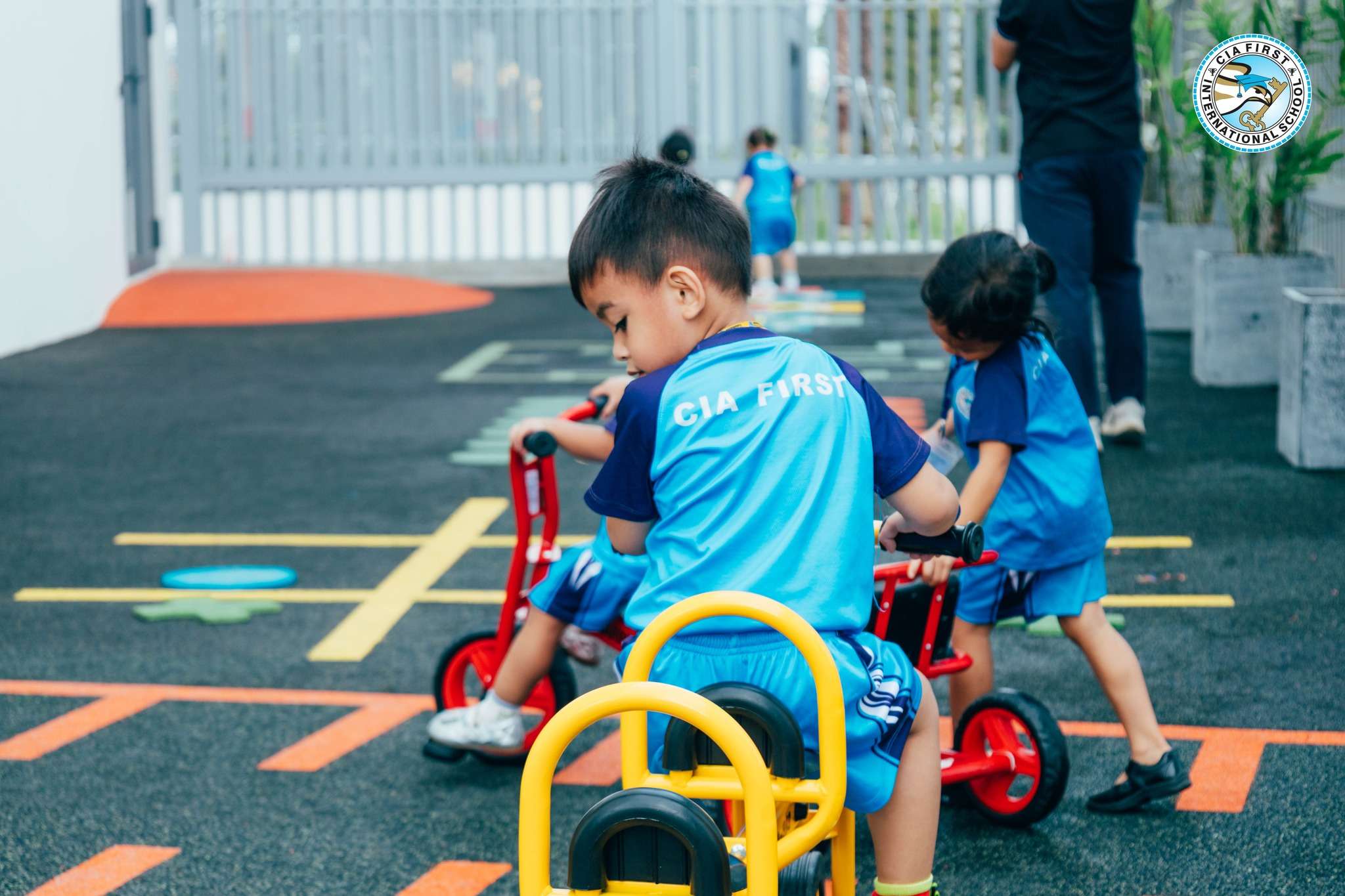 Children at CIA FIRST Russey Keo Kindergarten riding bicycles and participating in outdoor play activities to support active learning.