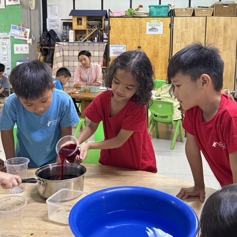 Students at Asian Hope International School engaging in EYFS hands-on numeracy activities using number cards and building blocks