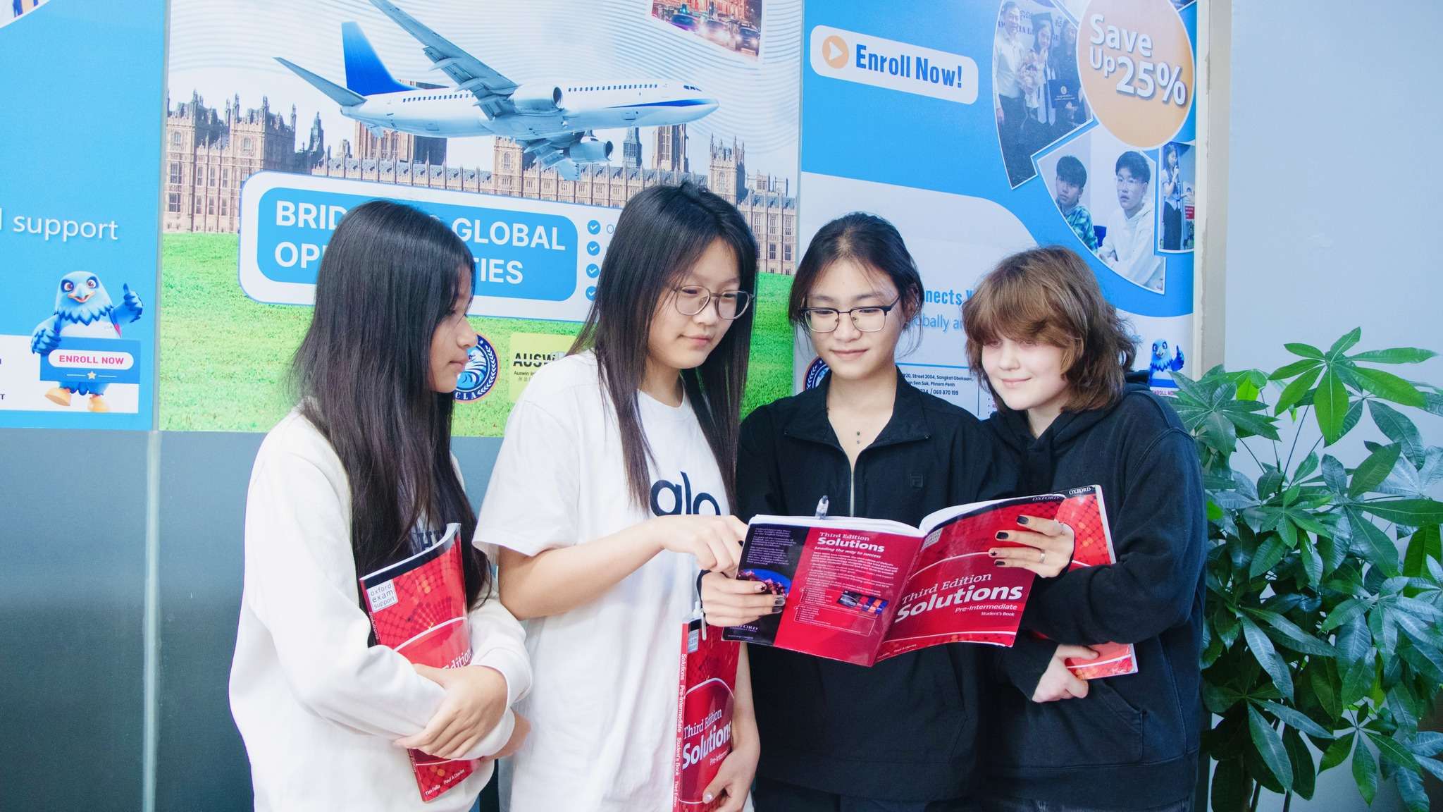 Students participating in English learning activities holding textbooks at Cambodia Language Academy.