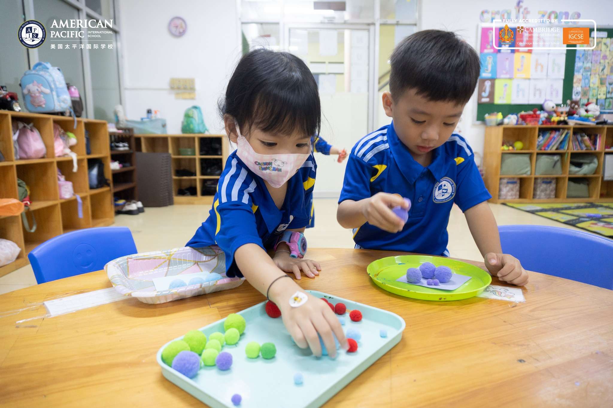 Children at American Pacific International School, Daun Penh Campus practicing color sorting and number matching with classroom materials.