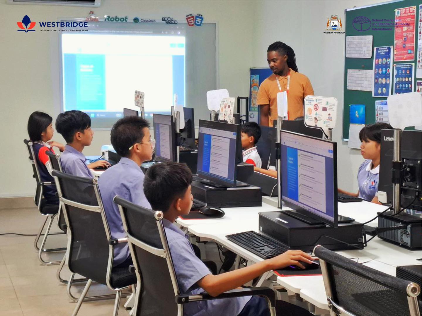 Students at Westbridge International School of Phnom Penh working on computers in a classroom during a science and technology lesson.