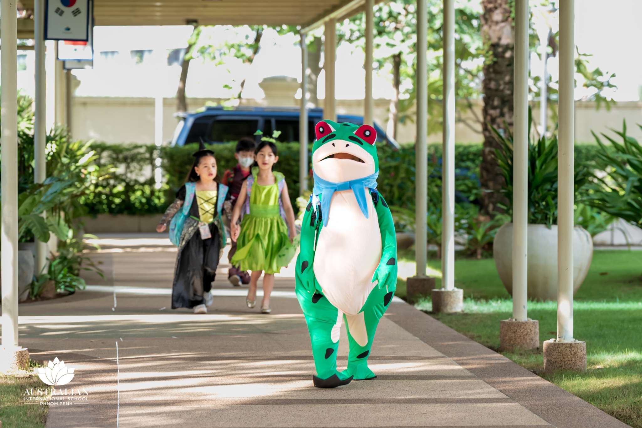 Children at AISPP Phnom Penh dressed in Halloween costumes walking outdoors on school campus