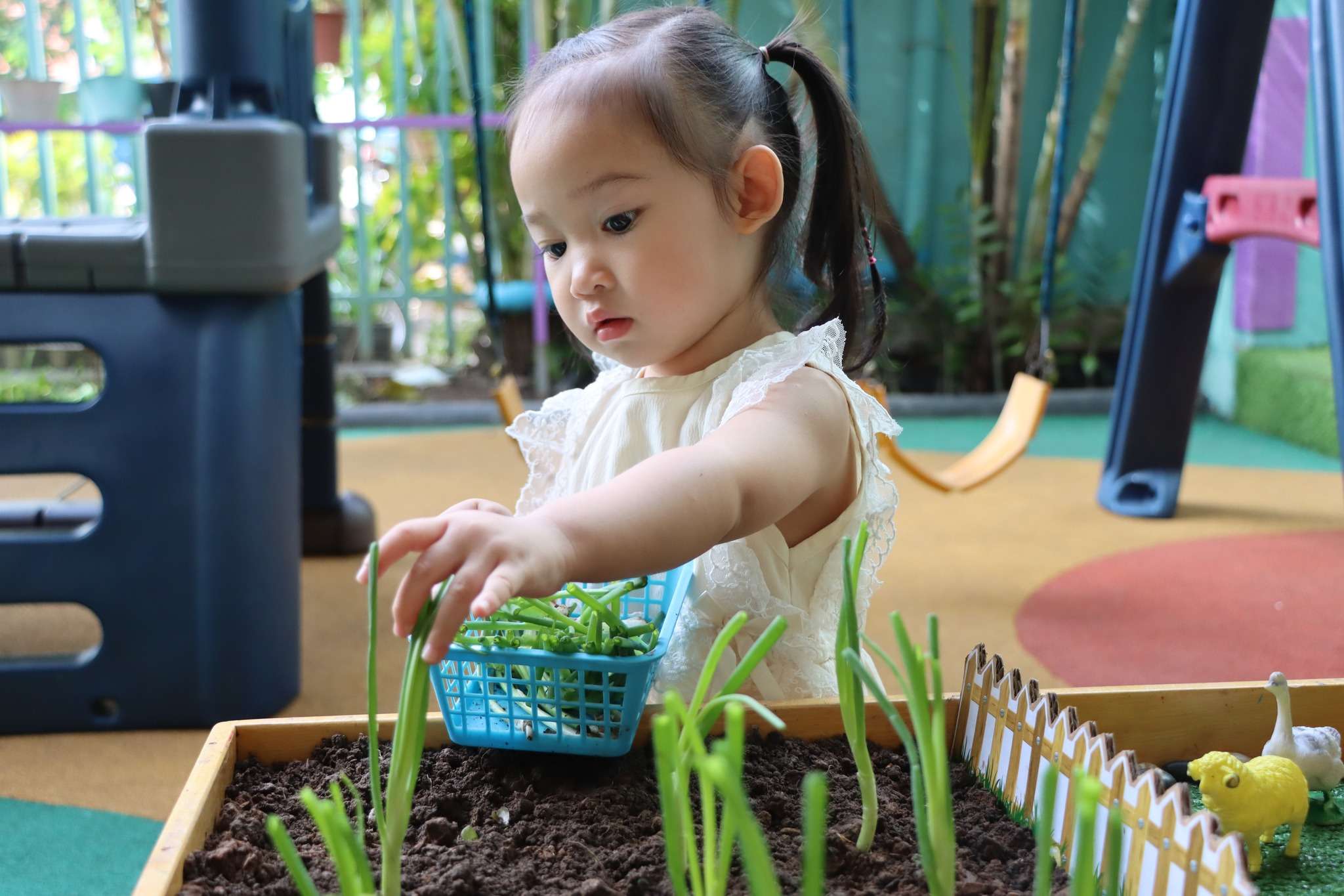 Children at Eco International School participating in a hands-on harvesting sensory activity using natural materials.