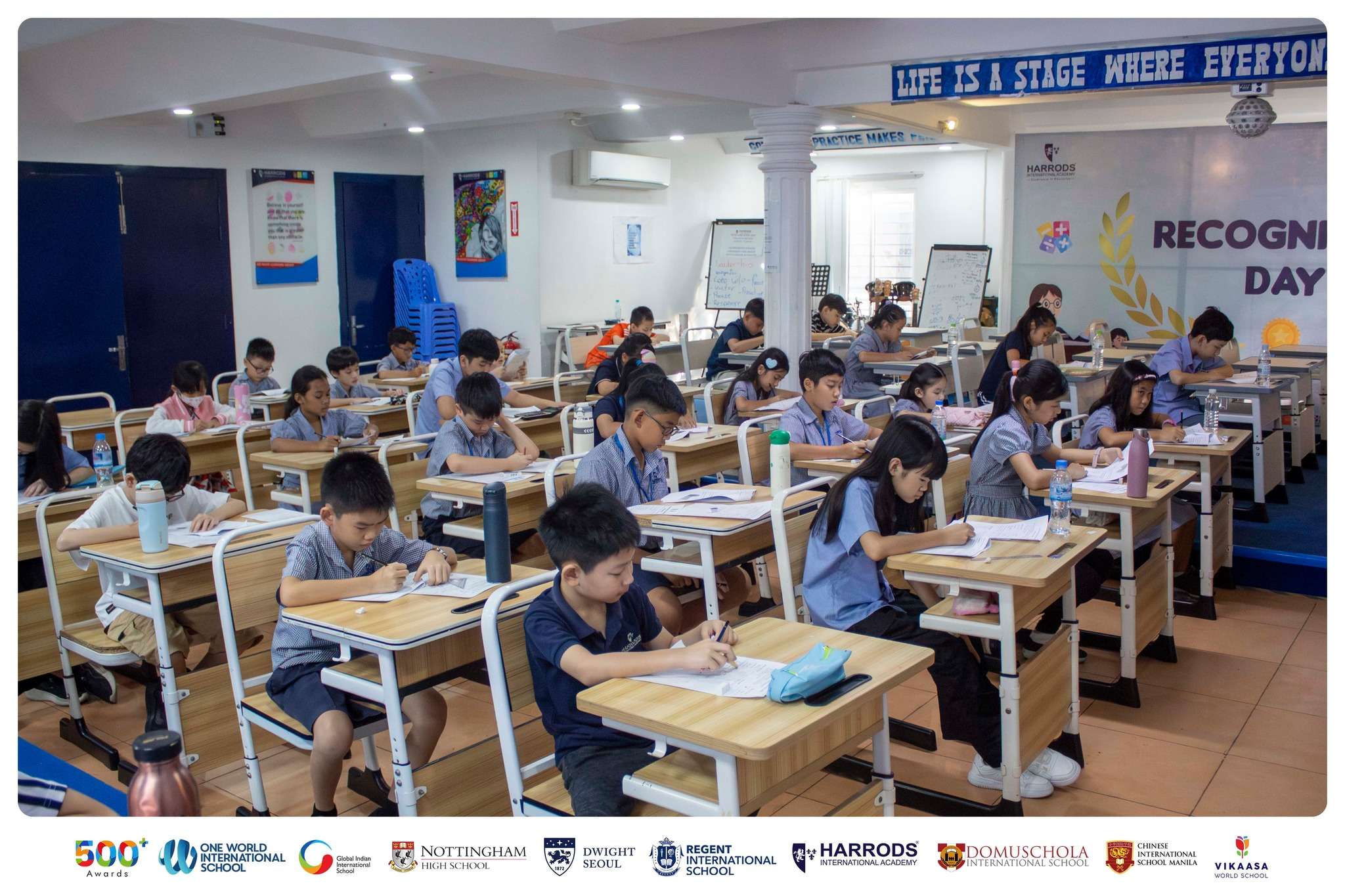 Students at Harrods International Academy participating in the American Mathematics Olympiad exam in a classroom setting.