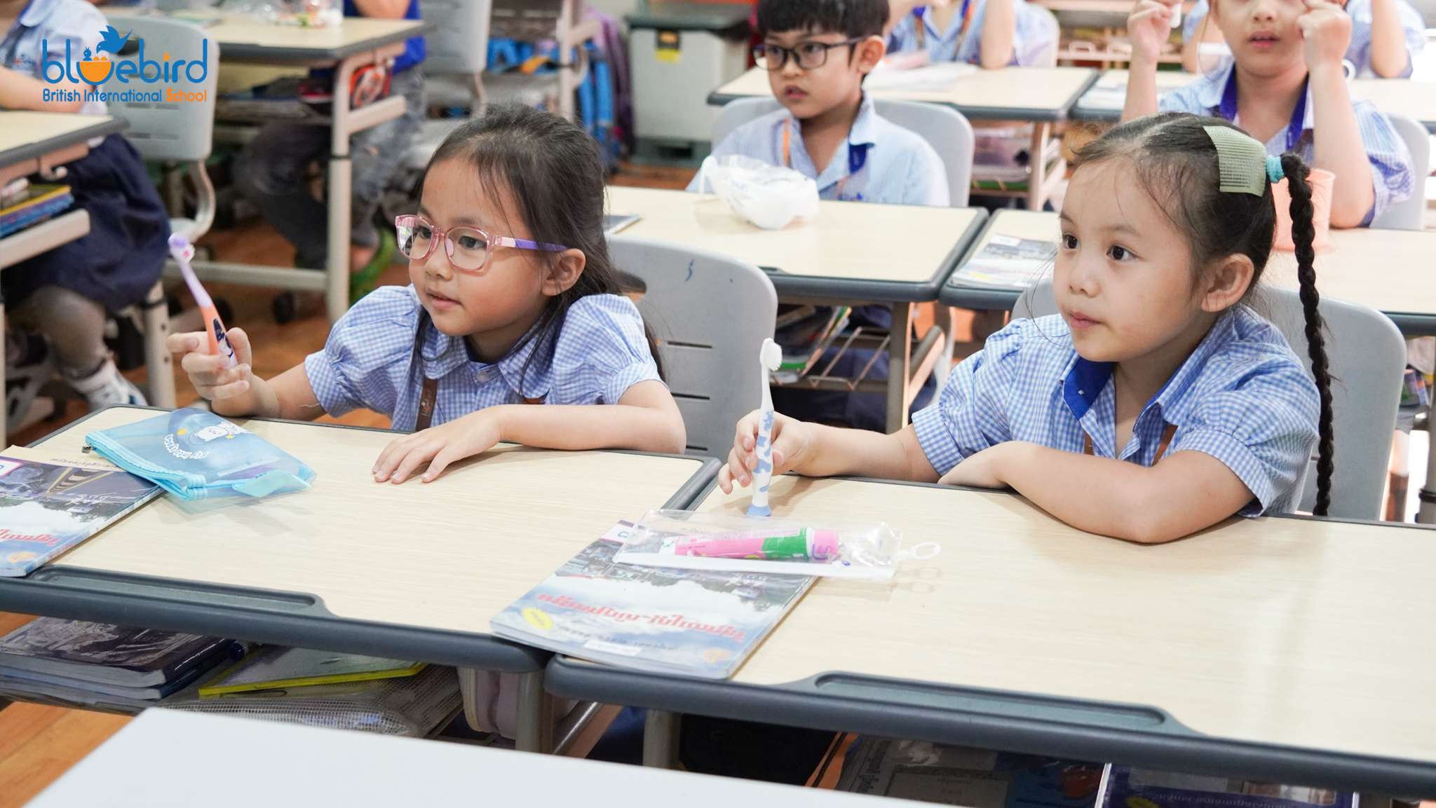 Primary students at Bluebird British International School participating in an interactive dental health lesson using visuals and classroom demonstrations.