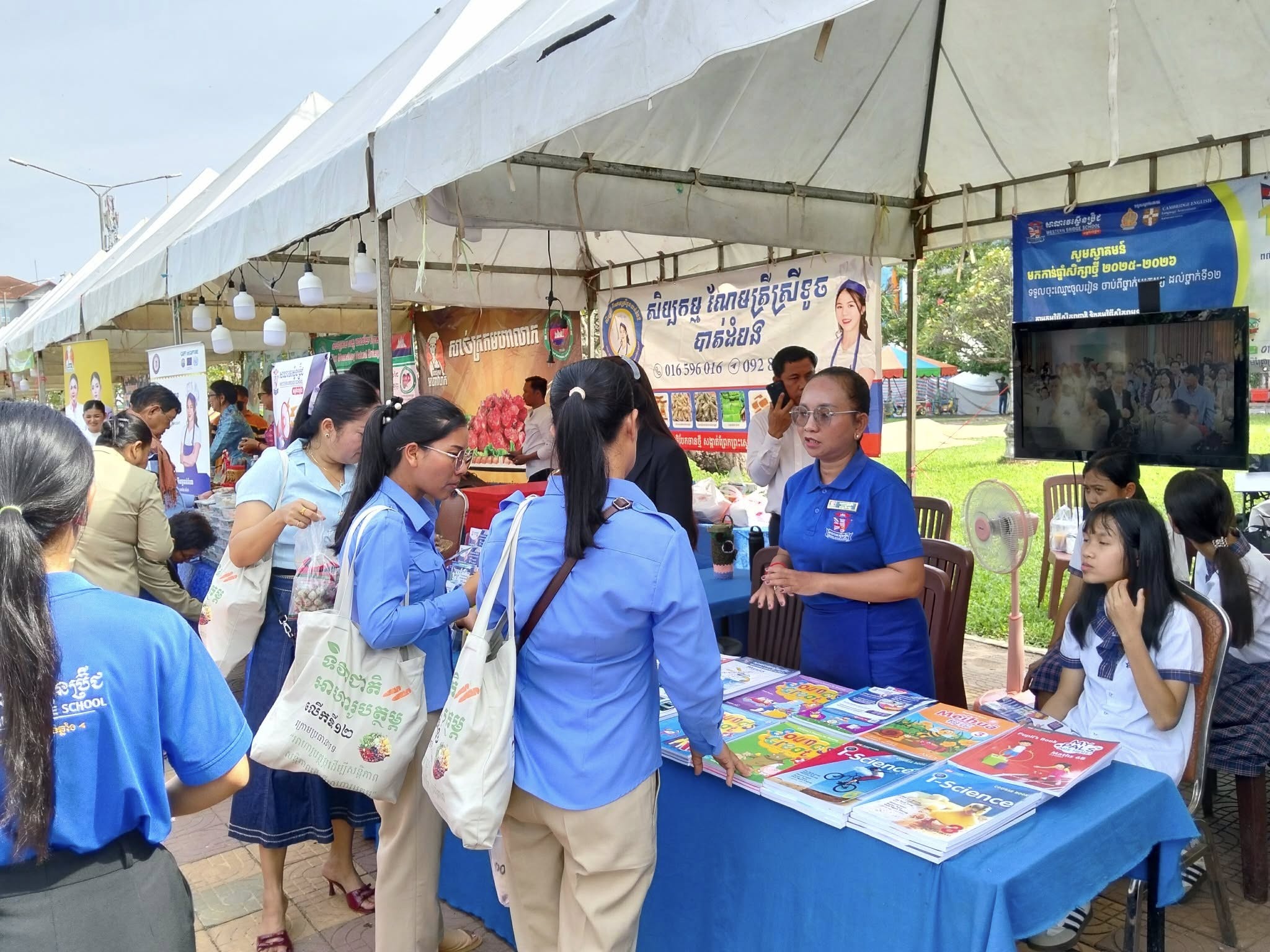 Staff and teachers from Western Bridge School Kampong Chhnang engaging with parents and showcasing kindergarten programs during a community education fair.