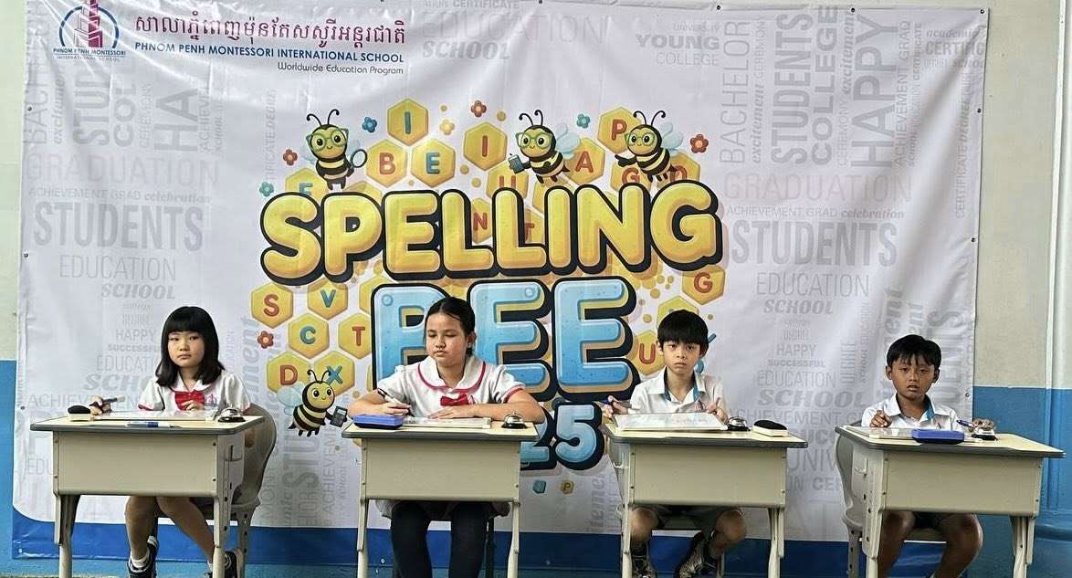 Students participating in the Spelling Bee Final Round at Phnom Penh Montessori International School, seated on stage with certificates and competition banners.