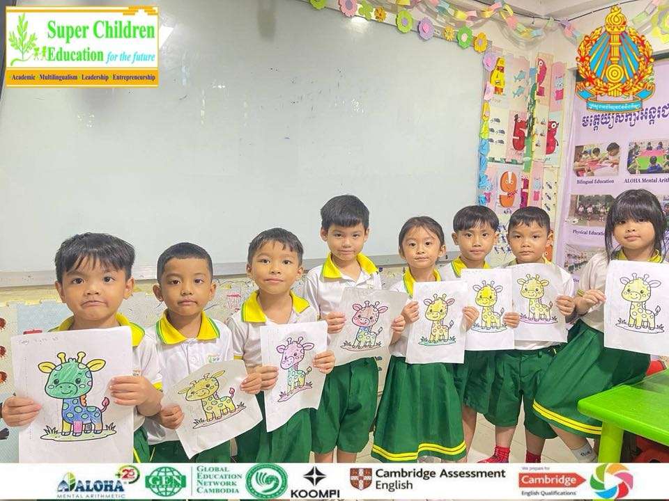 Children at Super Children Education Cambodian School working on artwork and standing with completed drawings.