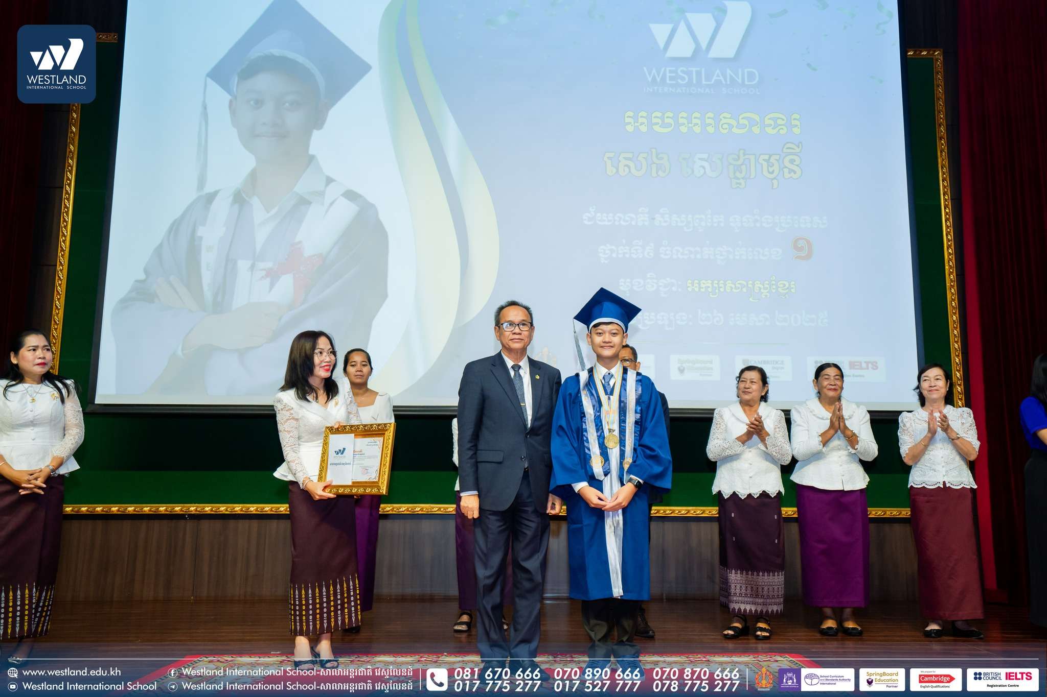 Student receiving graduation certificate at Westland International School ceremony surrounded by school leaders and faculty