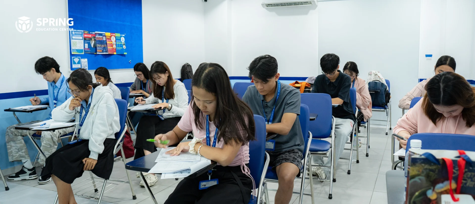 Students sitting the Spring Education Center final exam in a supervised classroom environment in Cambodia