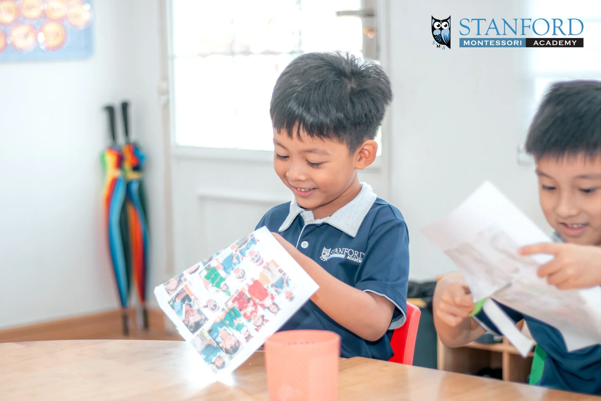 Children at Stanford Montessori Academy working on a classroom family collage through hands-on Montessori activities