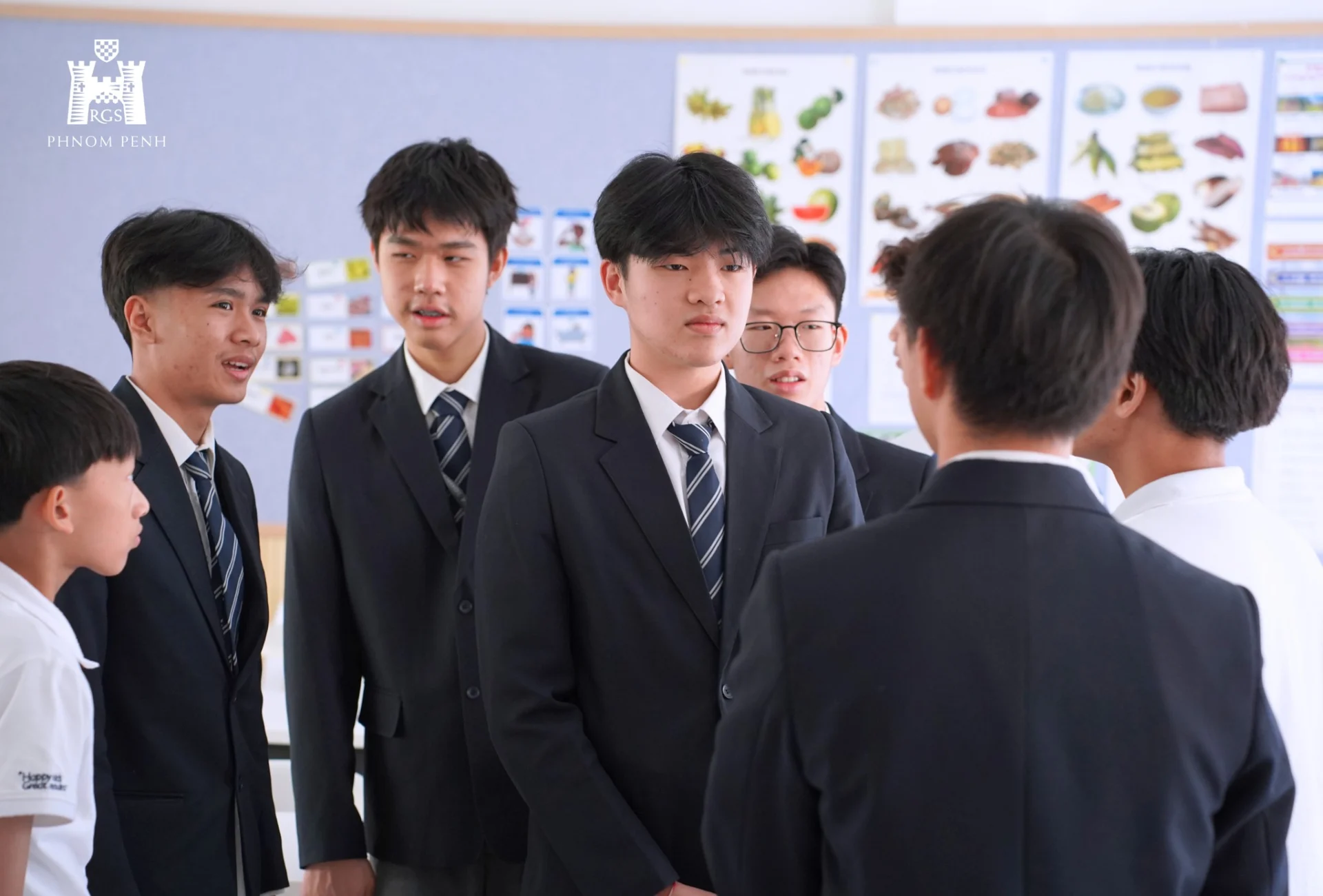 Students attending an IGCSE information event and academic presentation at Reigate Grammar School Phnom Penh with teachers and parents engaged in discussion