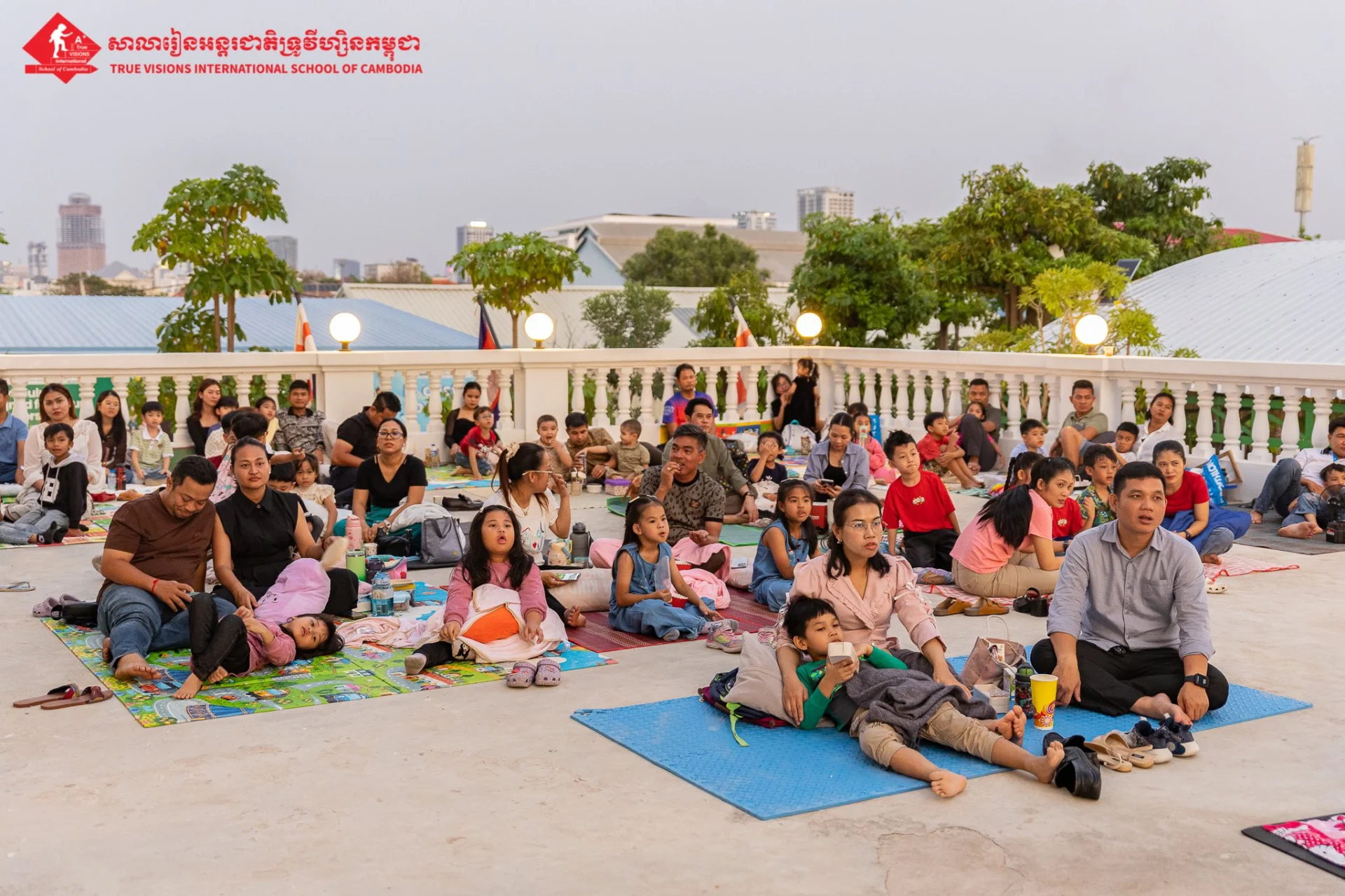 Students and families attending a community movie night event organized by True VISIONS International School of Cambodia