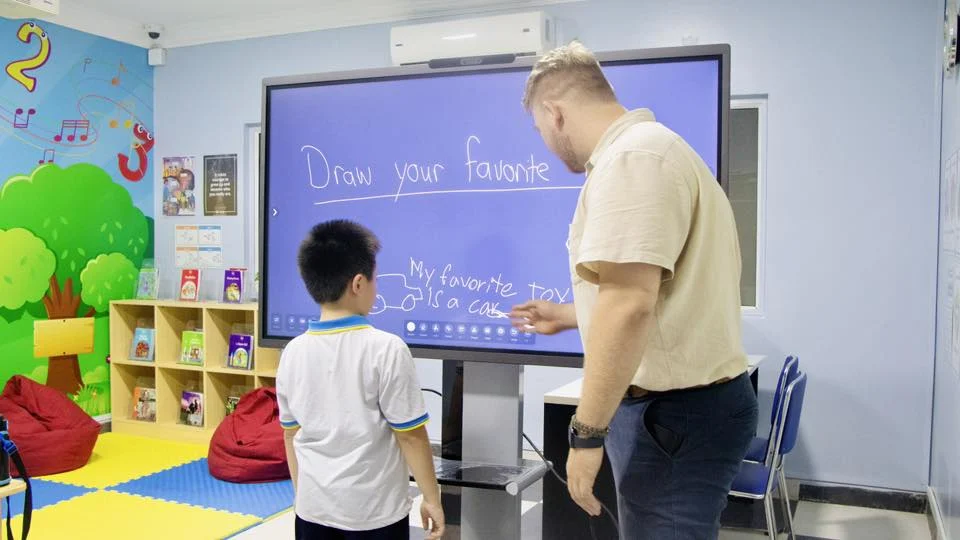 Students learning English in a small classroom with a teacher at Cambodia Language Academy in Phnom Penh