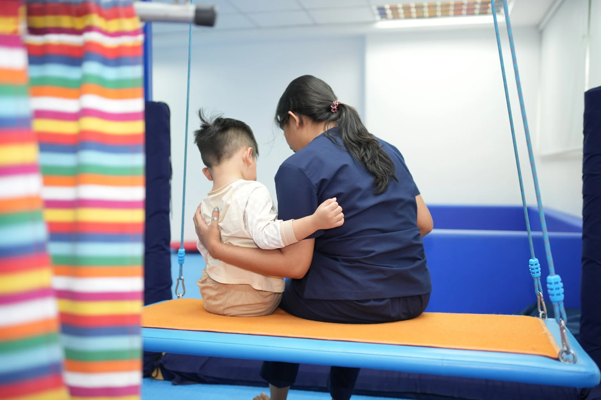 Occupational therapist supporting children with sensory regulation, movement, and fine motor activities in an educational setting Category: Education
