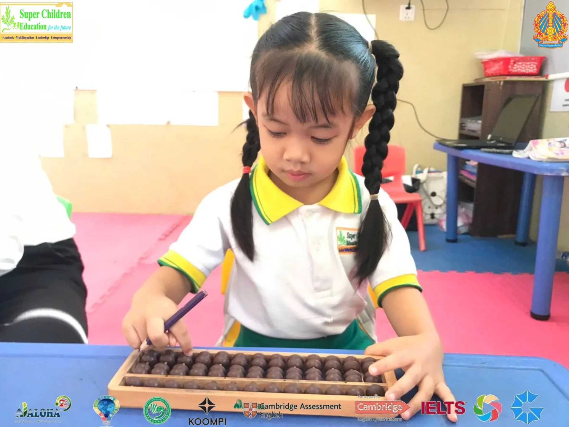 Young students at Super Student Education Cambodian School Koh Kong participating in hands-on classroom learning activities using abacuses and educational tools.